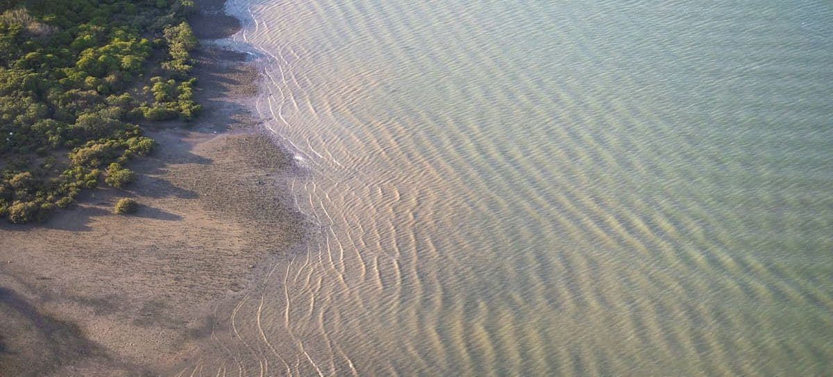 Aerial view of soft ripples across sand and shallow water