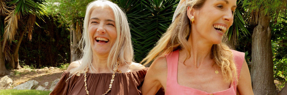 Two women laughing arm in arm in a sunny garden, for a guide to whether Daily Vitals is right for you