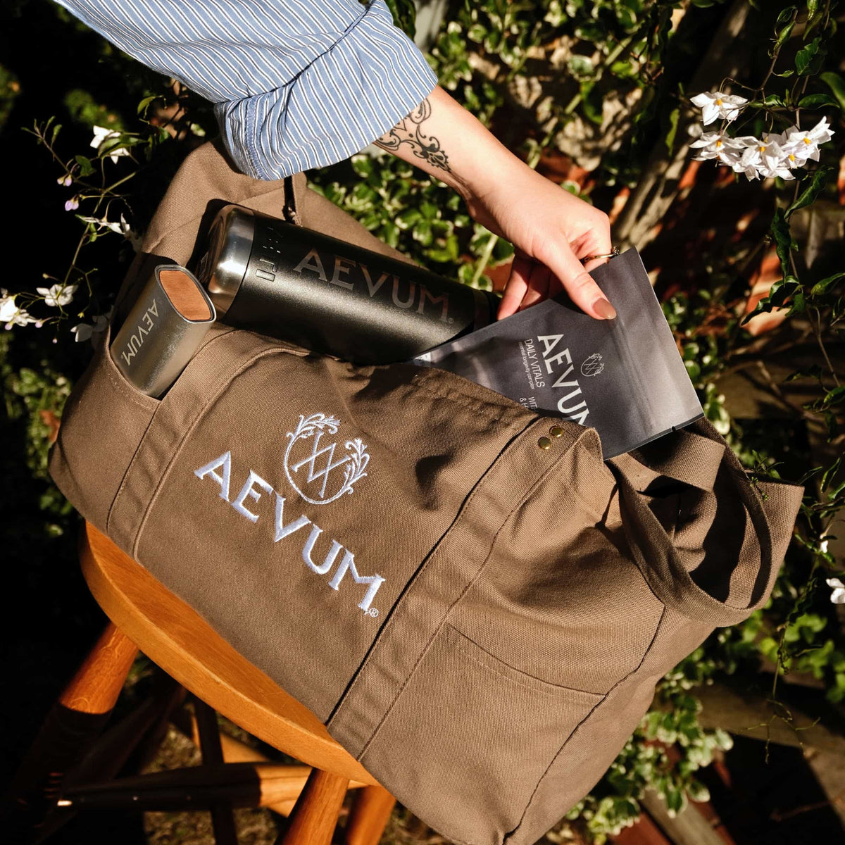 AEVUM branded duffel bag with travel bottle and pouch