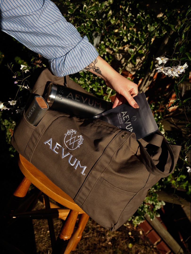 AEVUM branded duffel bag with travel bottle and pouch