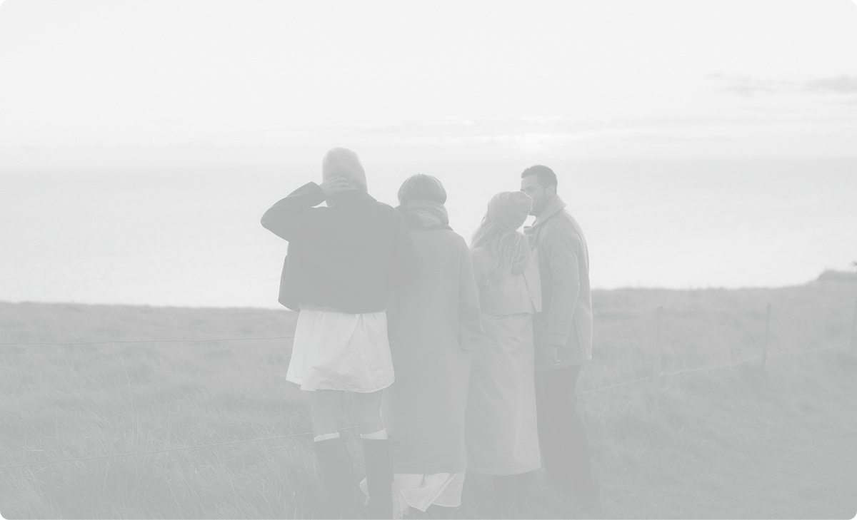Faded background image of four people looking out at the coast, background for AEVUM's ingredients section