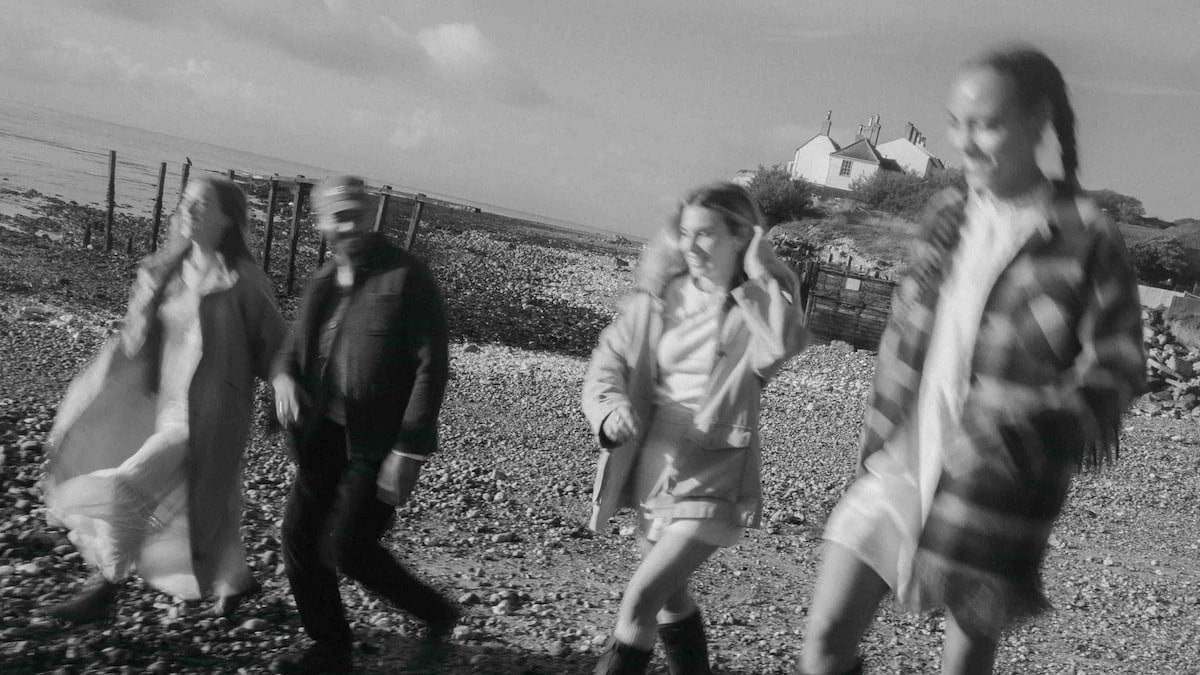 Two people walking on a beach, AEVUM partner programme banner