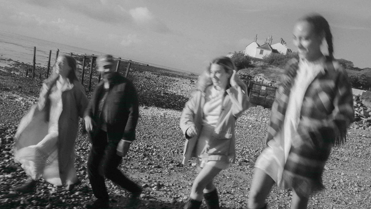 Two people walking on a beach, AEVUM partner programme banner