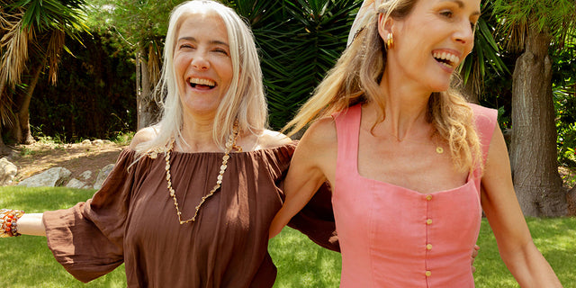 Two women laughing outdoors, representing month 3+ of AEVUM Daily Vitals — the compound effect