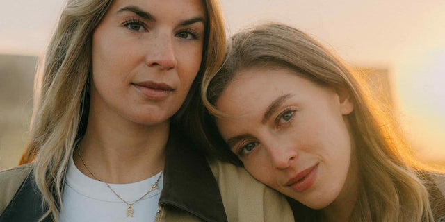 Two women leaning their heads together in golden evening light, illustrating weeks 5 to 6 of the Daily Vitals routine